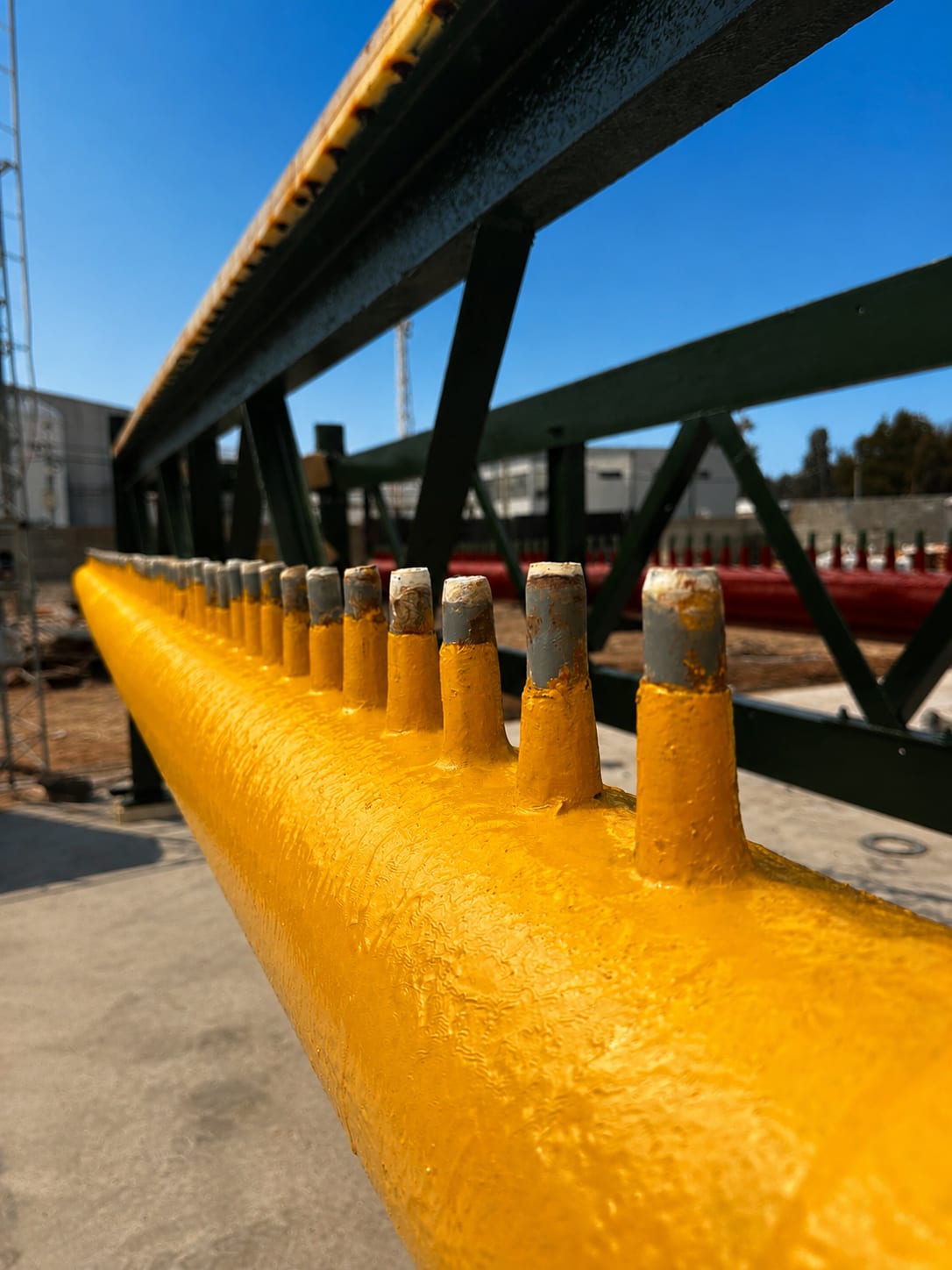 Detalle de un colector de proceso amarillo con múltiples salidas en una instalación industrial